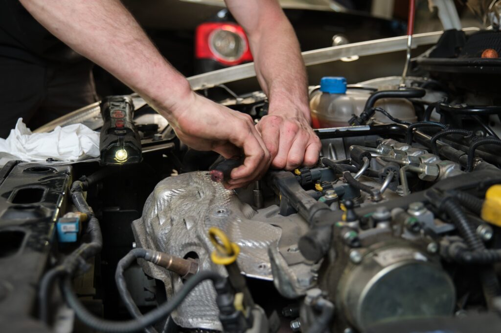 Close up of car mechanic hands doing car service and maintenance.